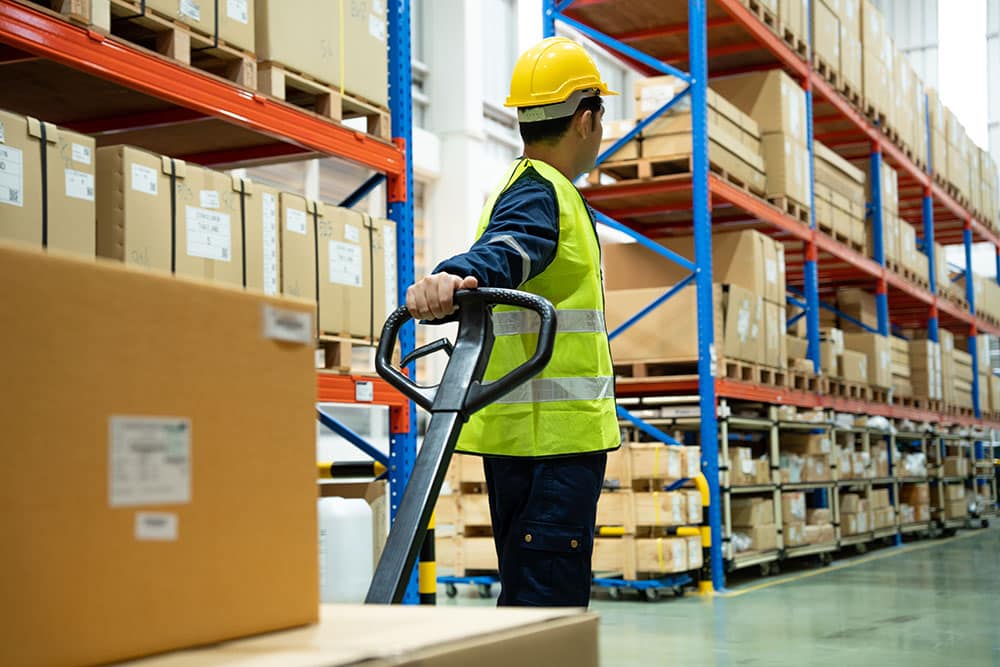 Warehouse worker pull pallet truck after inspects goods in inven