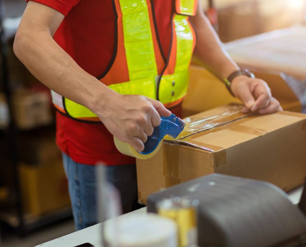 staff worker tape packing seal products box prepare for shipping